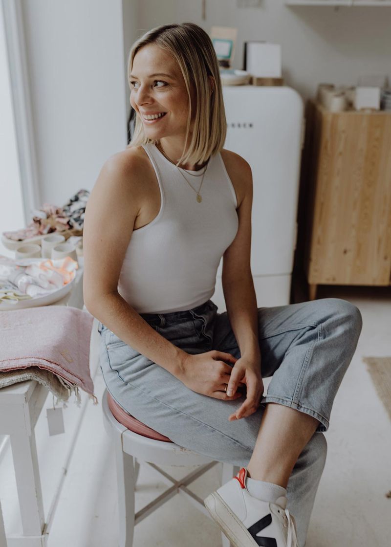 Dr. med. Rieke Hermann - Fachärztin für Frauenheilkunde sitzt auf einem Stuhl und schaut zur Seite.